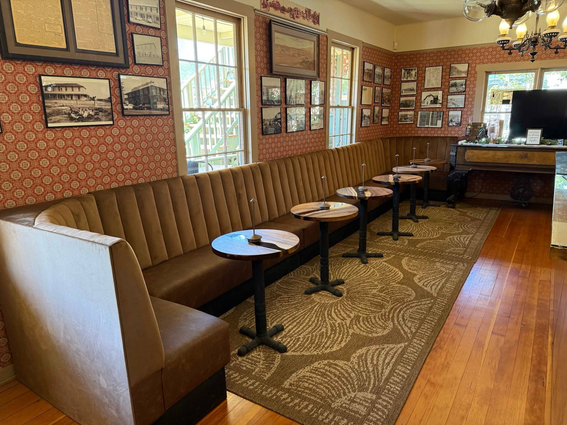 Tasting room seating at Big Nose Winery with vintage wallpaper and historic photos
